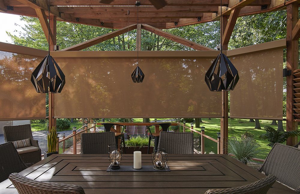 Cable guided exterior roller shade on a balcony